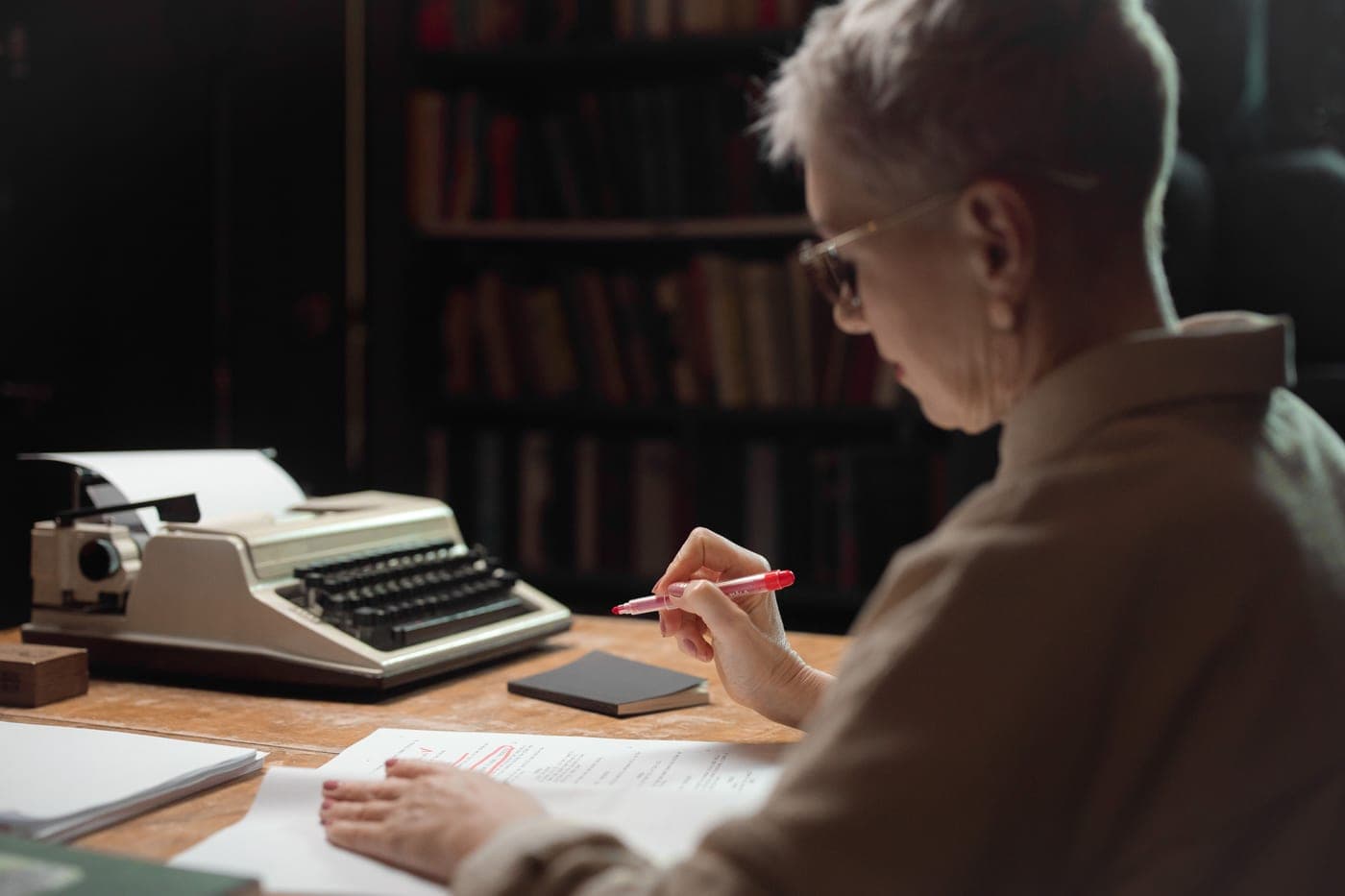 A person marking up printed pages with a pen