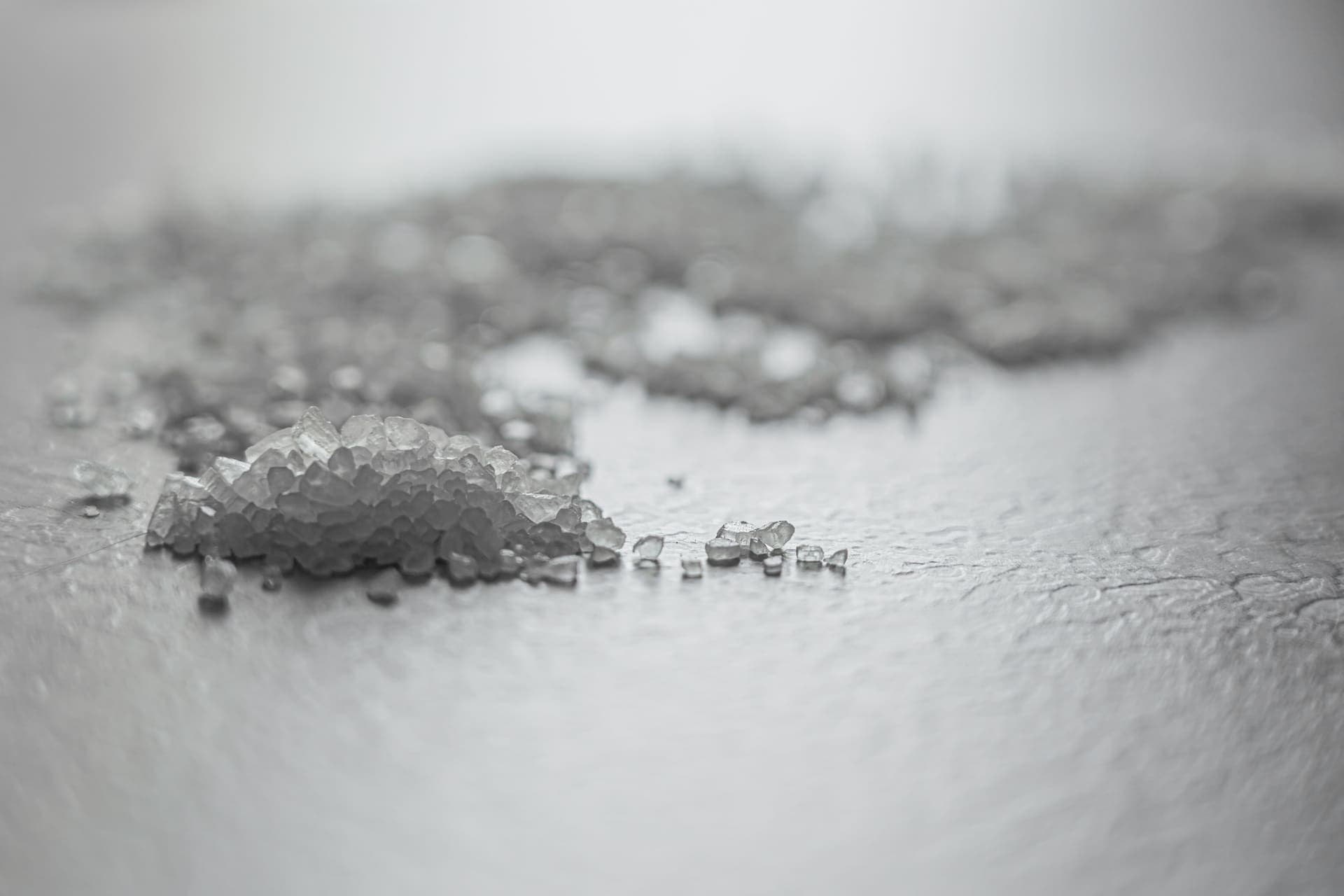 Coarse salt crystals scattered on a pale surface