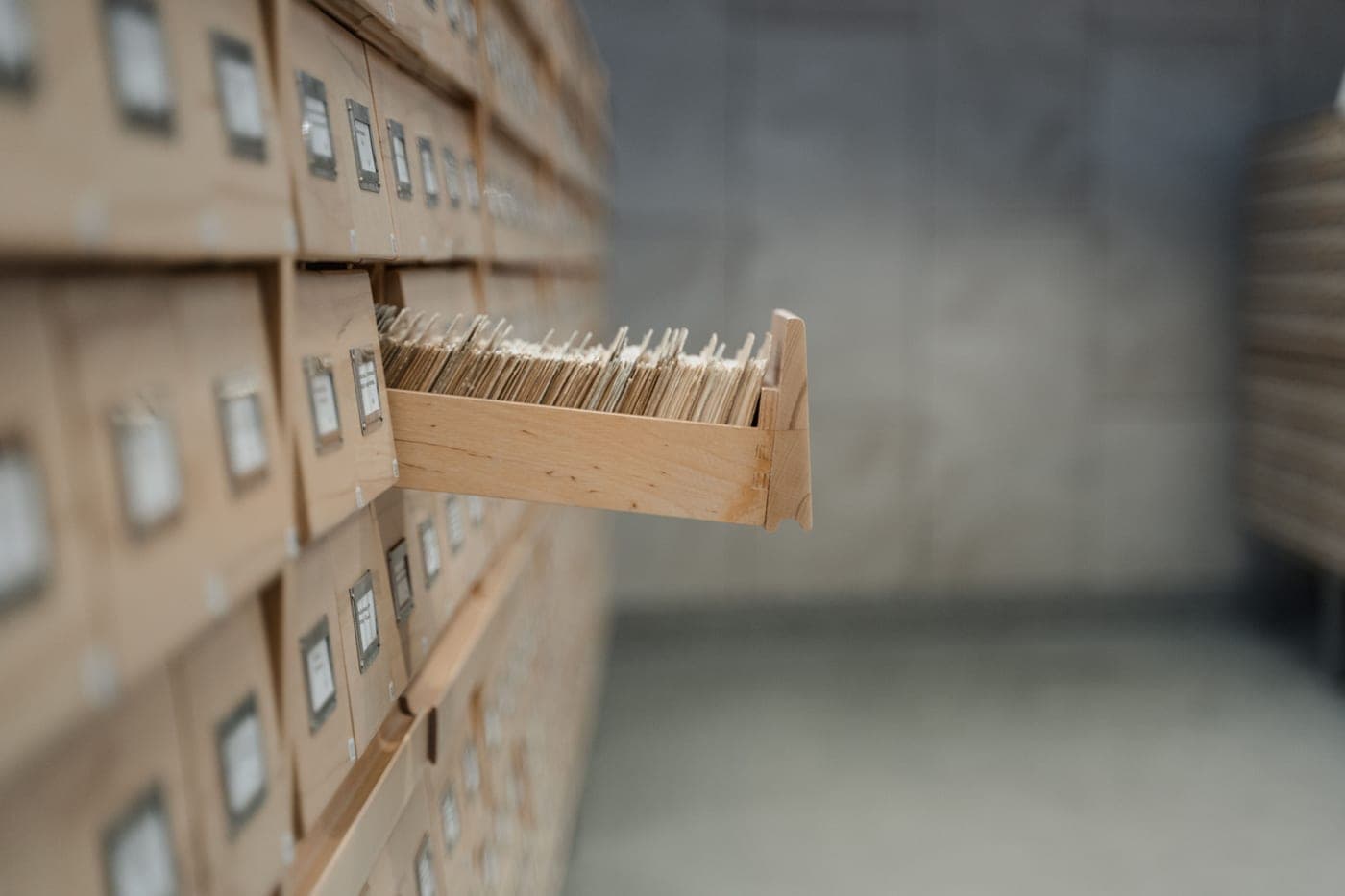 A wall-mounted rack of labeled index card drawers